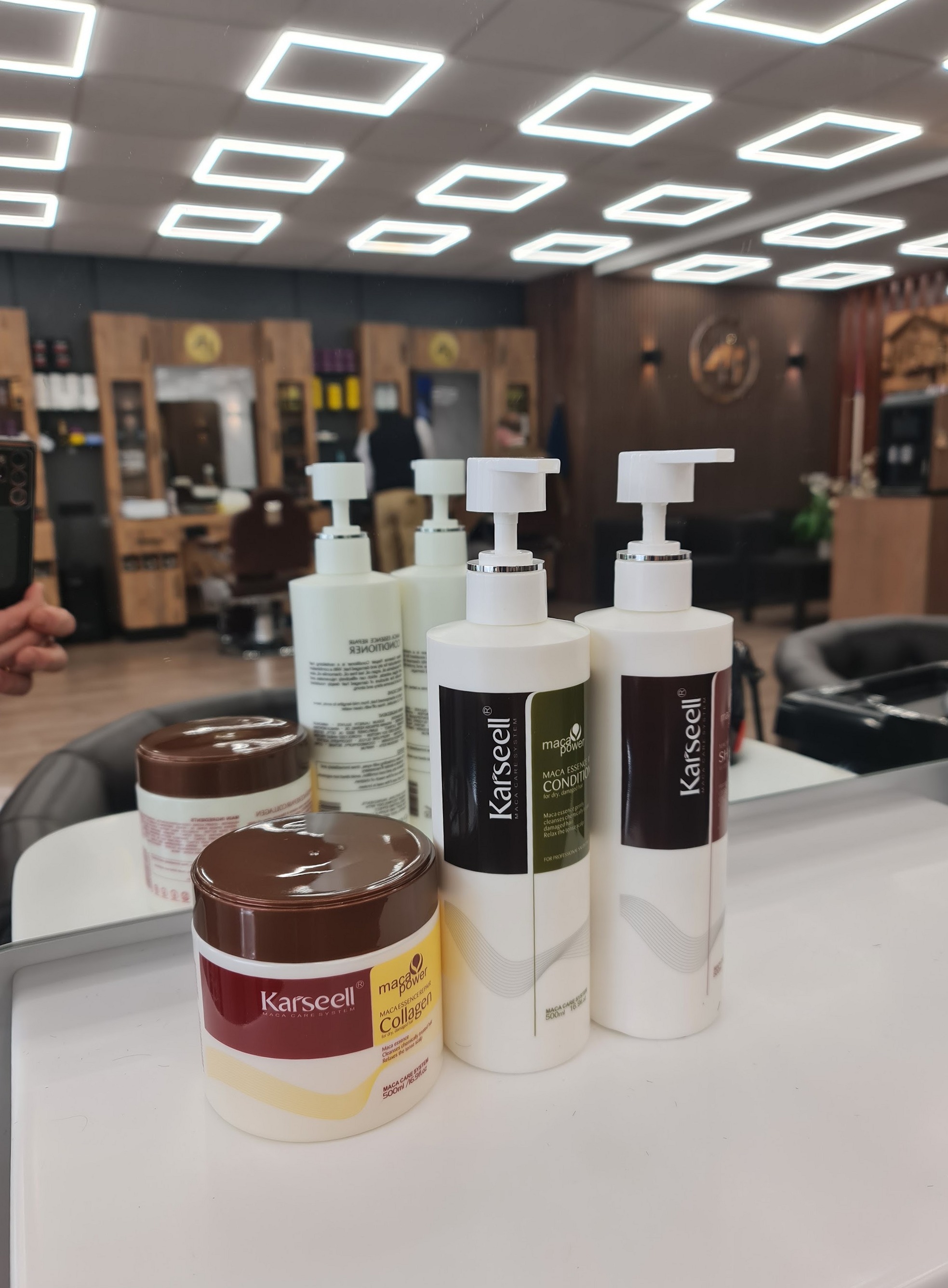 Flessen en potten Karseell haarverzorging op een werkplek in de salon